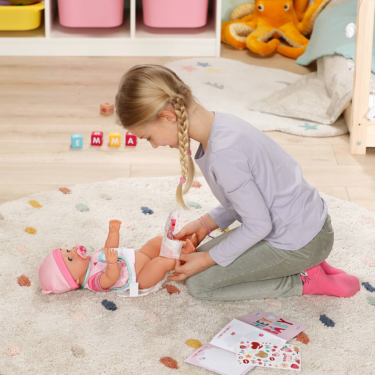 Кукла Baby Born Милая Эмма с комбинезончиком 43 см (840504) Комплектация  Кукла 43 см, 2 комплекта одежды, бутылочка, пустышка, подгузники, тарелка, ложка, горшок, браслет дружбы для девочки и куклы, детский альбом с наклейками, инструкция.